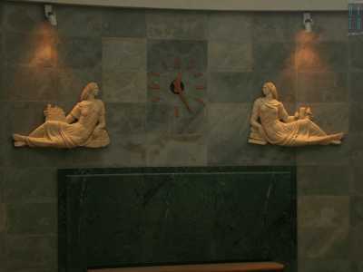 ...e le due figure femminili in ceramica allegorie delle Poste e dei Telegrafi, poste ai lati dell'orologio come sovrapporta dell'ingresso, non fanno altro che rimarcare l'identit� della sala 